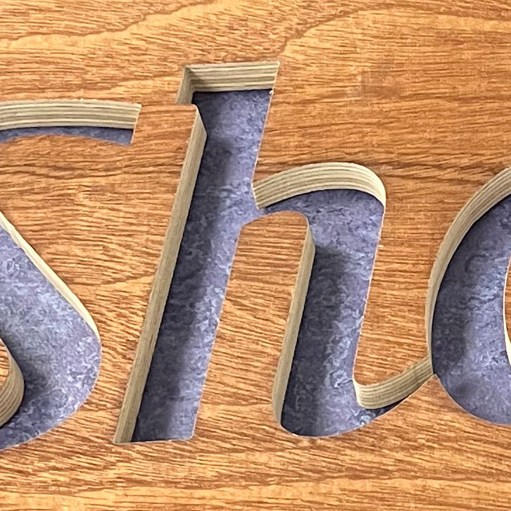 Close up of wooden sign precision cut out by North West Waterjets