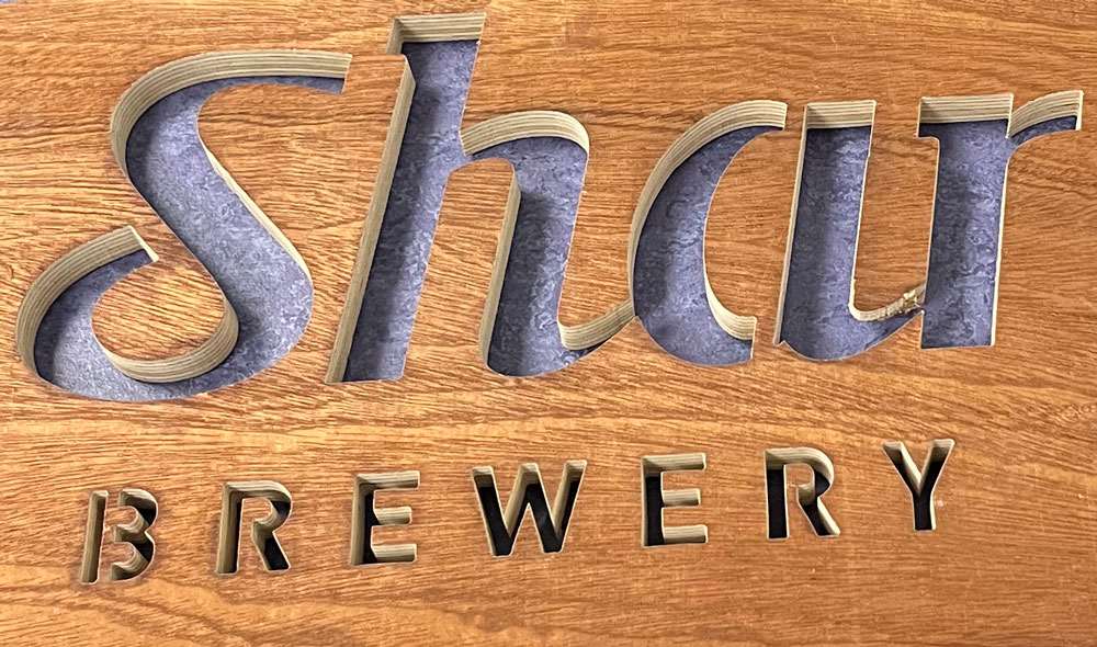 Section of wooden sign precision cut out by North West Waterjets